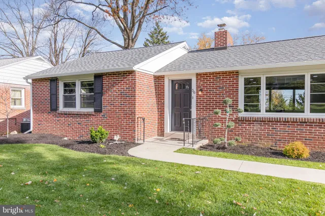 a front view of a house with a garden and yard