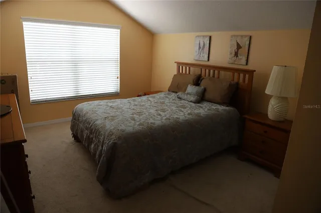a bed sitting in a bedroom next to a window