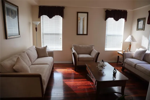 a living room with furniture wooden floor and a window