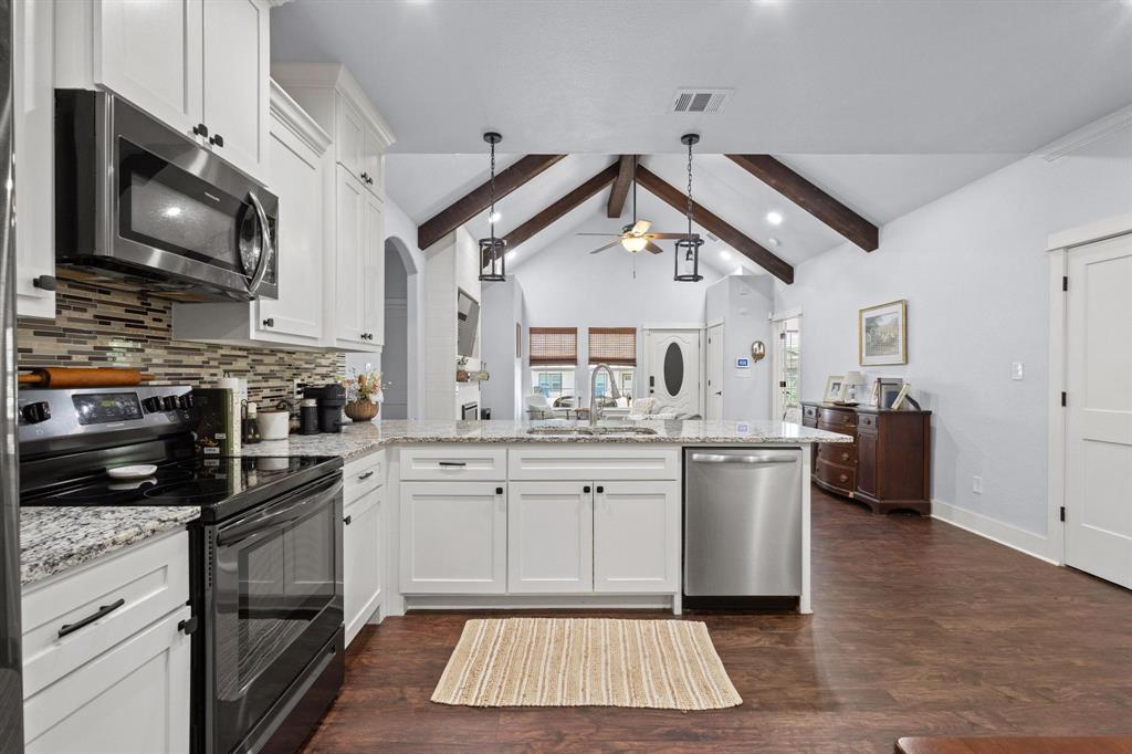 610 West Elm Street Denison, TX 75020 - Photo 11 of 26 a kitchen with stainless steel appliances a stove a sink and a microwave