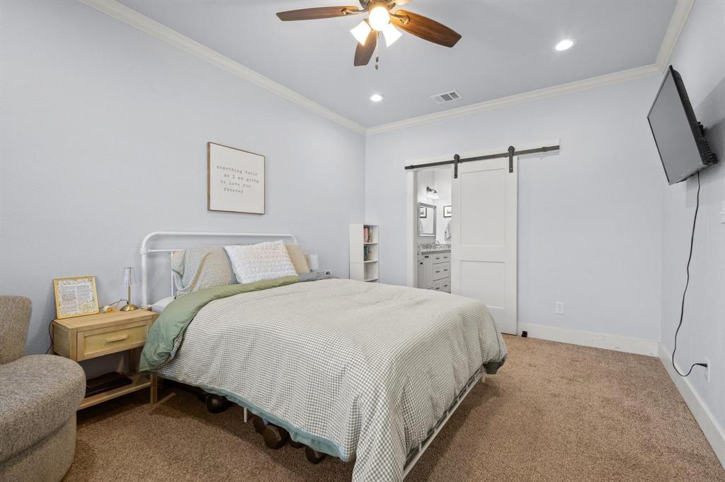 610 West Elm Street Denison, TX 75020 - Photo 12 of 26 a spacious bedroom with a bed and a chandelier