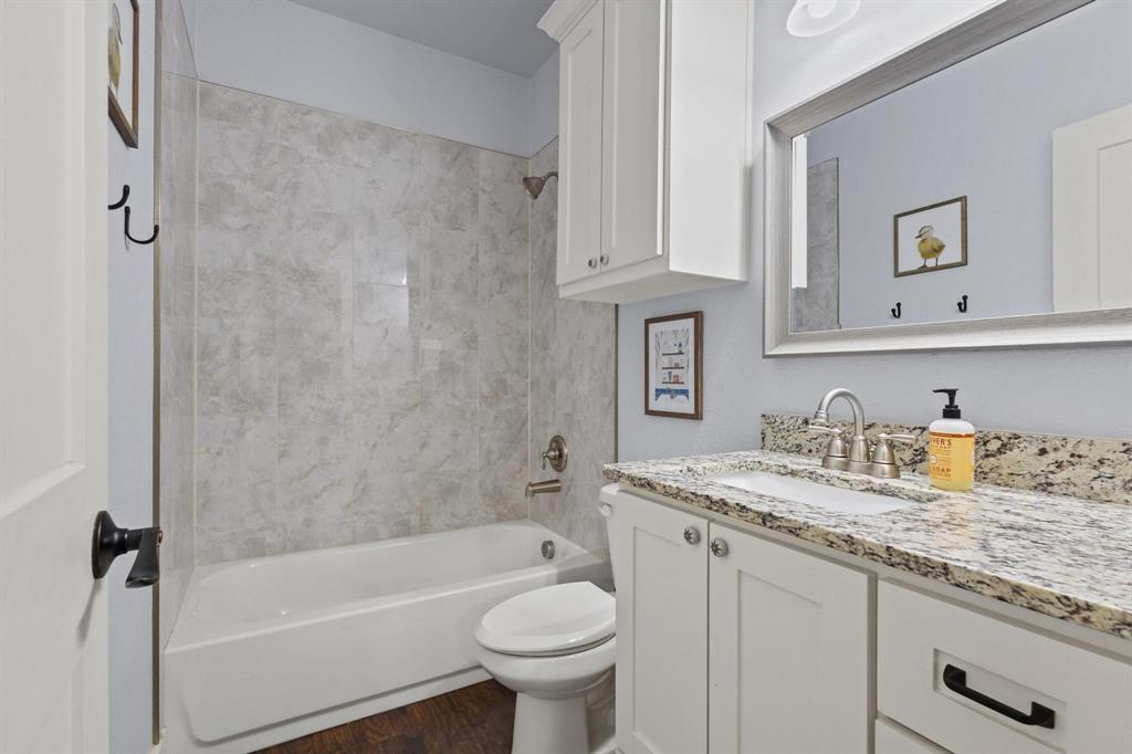 610 West Elm Street Denison, TX 75020 - Photo 18 of 26 a bathroom with a granite countertop sink toilet and shower