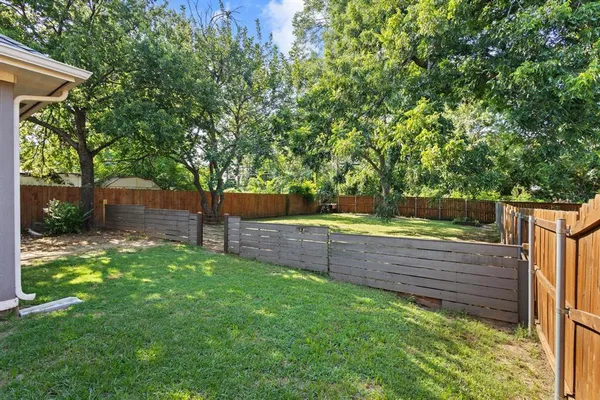 a view of a backyard with wooden fence