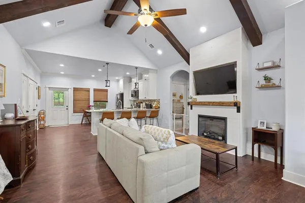 a living room with furniture a fireplace and a flat screen tv