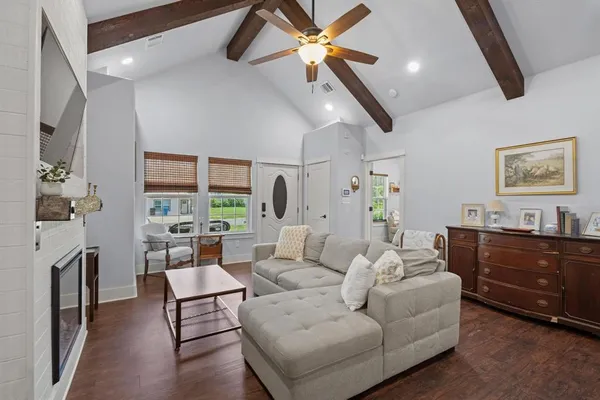 a living room with furniture a fireplace and a chandelier