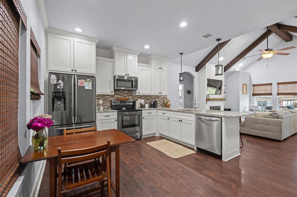 610 West Elm Street Denison, TX 75020 - Photo 10 of 26 a kitchen with kitchen island granite countertop lots of counter top space and stainless steel appliances