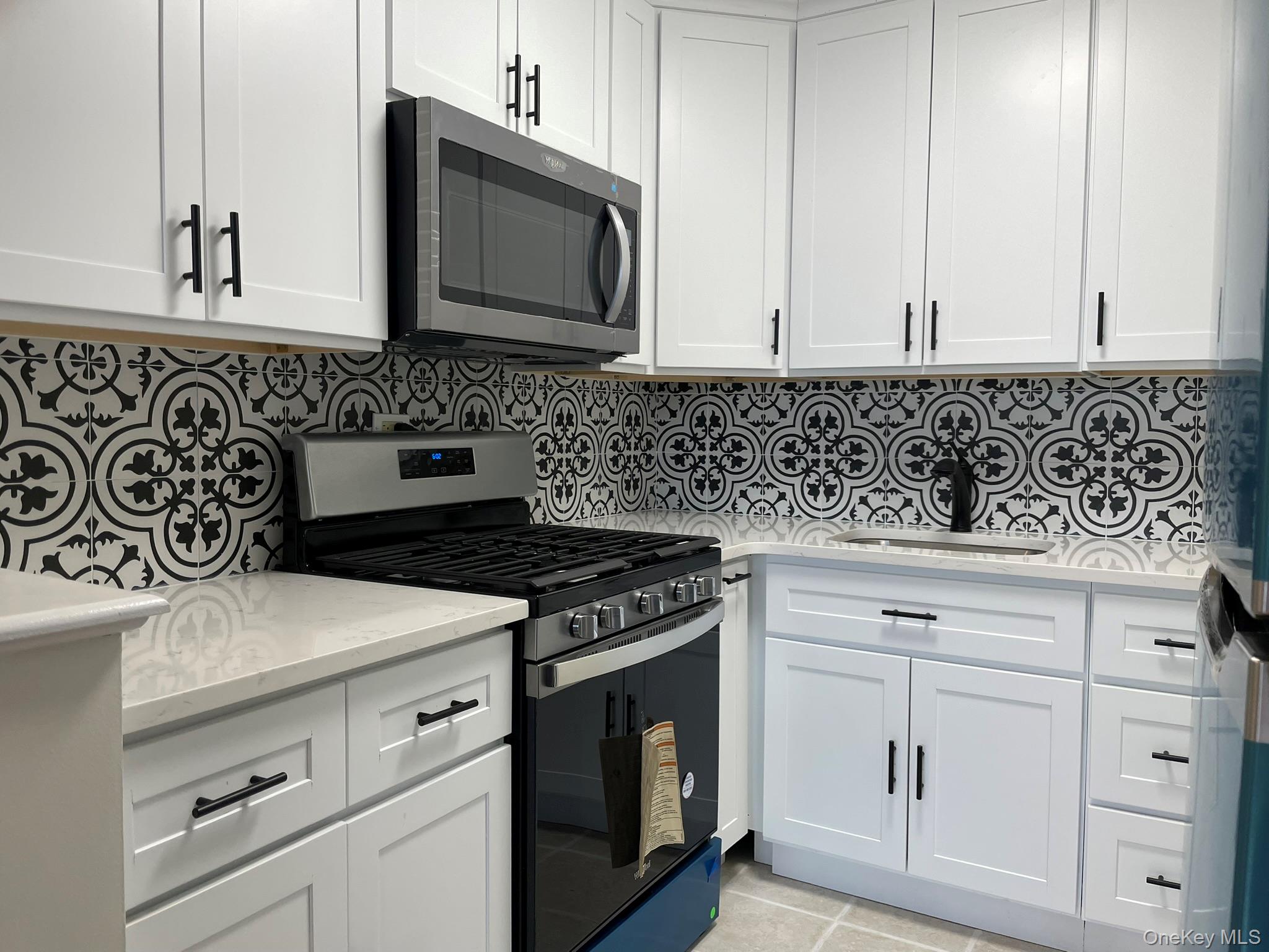 301 West 110th Street, Unit 14F Manhattan, NY 10026 - Photo 5 of 18 Kitchen featuring appliances with stainless steel finishes, a sink, and white cabinetry