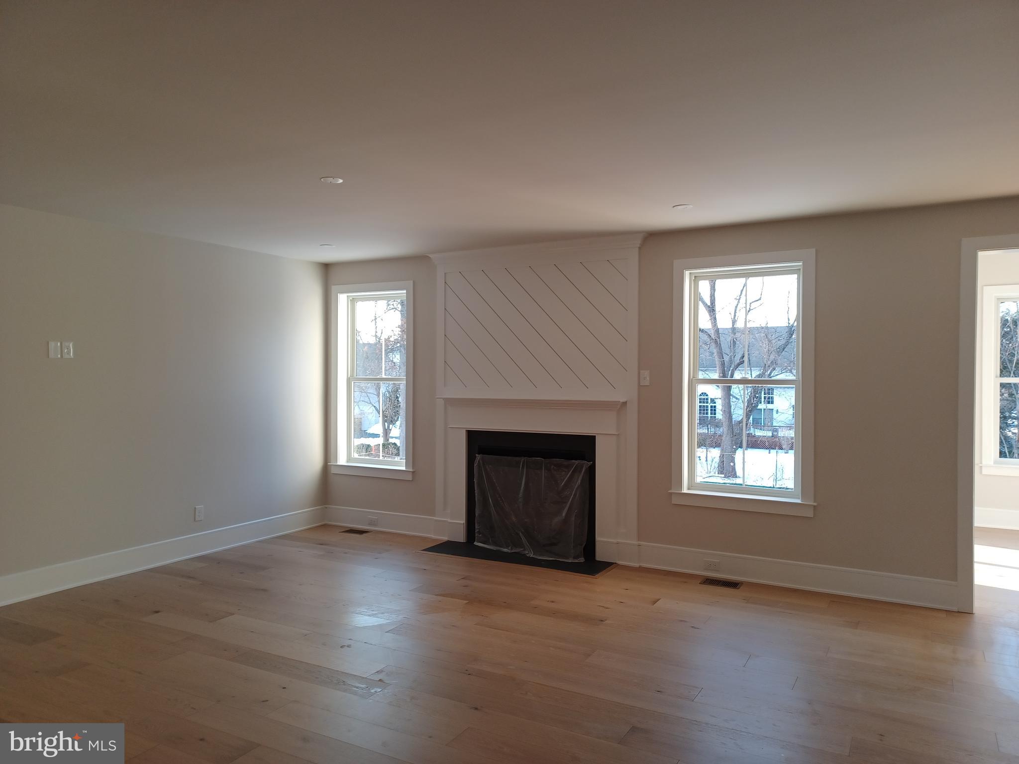 825 C Morris Road Lansdale, PA 19446 - Photo 6 of 8 an empty room with wooden floor fireplace and windows