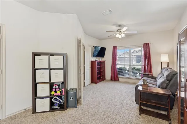 a living room with furniture a ceiling fan and a window