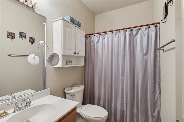 a bathroom with a sink a toilet and shower curtain