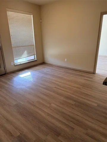 an empty room with wooden floor and entrance