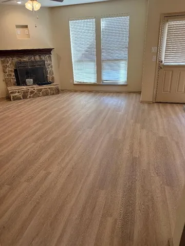 a view of empty room with wooden floor and fireplace