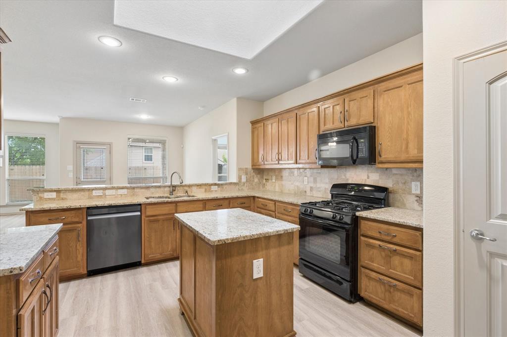 10205 Point Lobos Trail Fort Worth, TX 76177 - Photo 9 of 29 a kitchen with stainless steel appliances granite countertop a stove a sink and a refrigerator