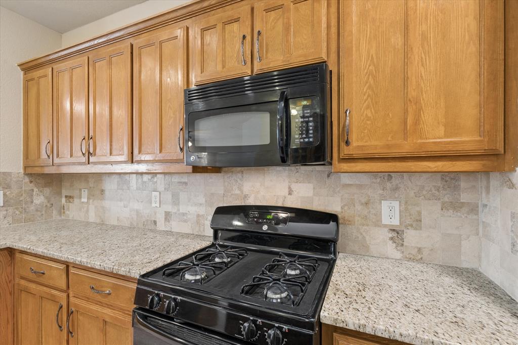 10205 Point Lobos Trail Fort Worth, TX 76177 - Photo 10 of 29 a kitchen with granite countertop stainless steel appliances a stove a microwave and cabinets