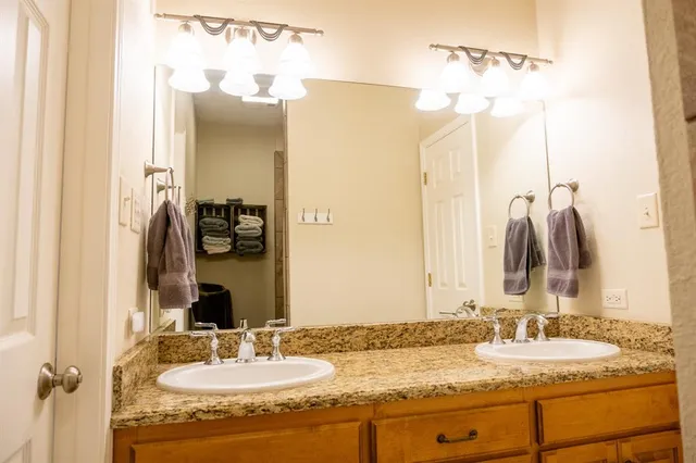 a bathroom with a granite countertop sink and a mirror