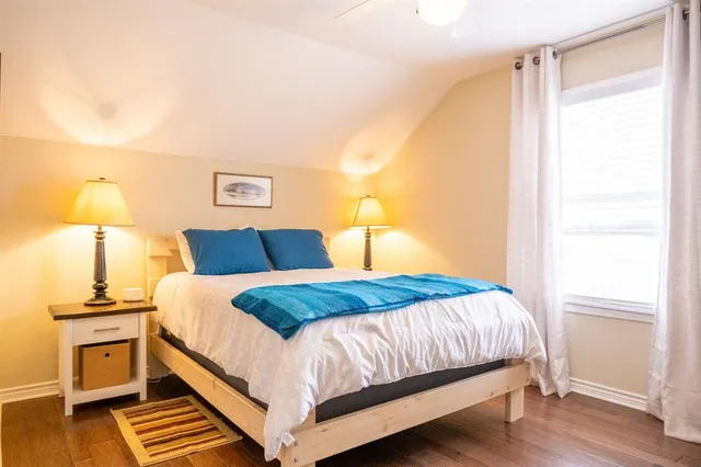 a bedroom with a bed and wooden floor