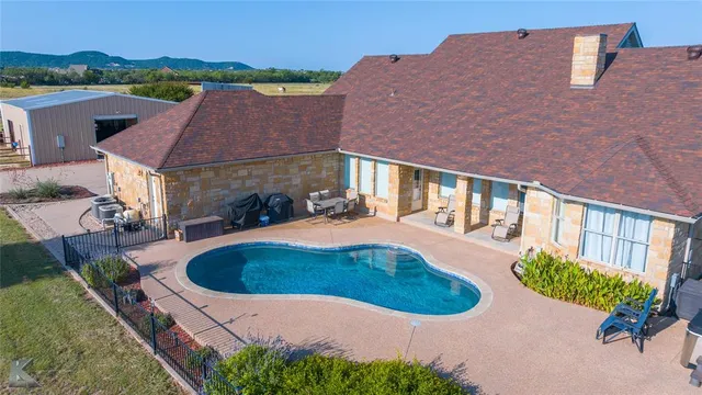 an aerial view of a house with outdoor space and a lake view in back