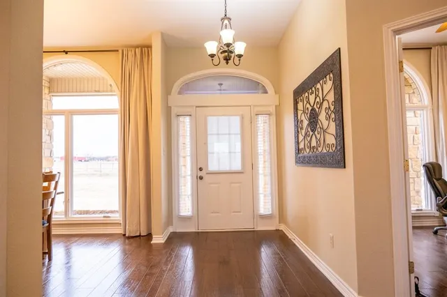 a view of a hallway with wooden floor and windows