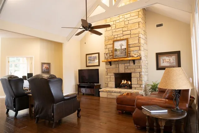 a living room with furniture a fireplace and a flat screen tv