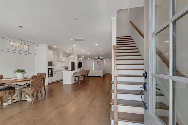 a living room with couches and kitchen view with wooden floor