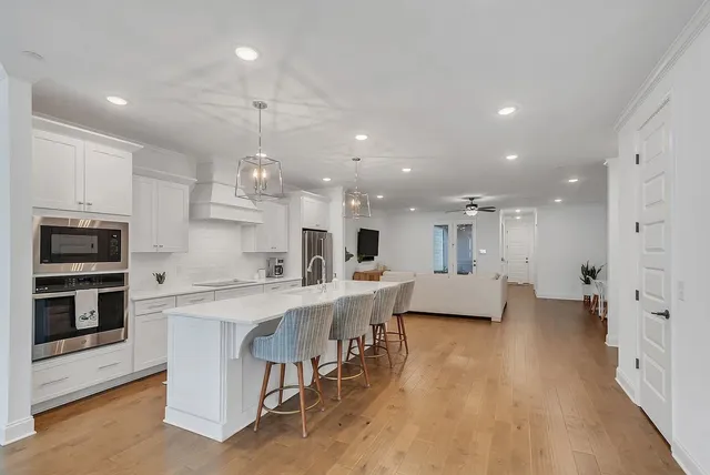 a large kitchen with kitchen island a stove a sink a dining table and chairs