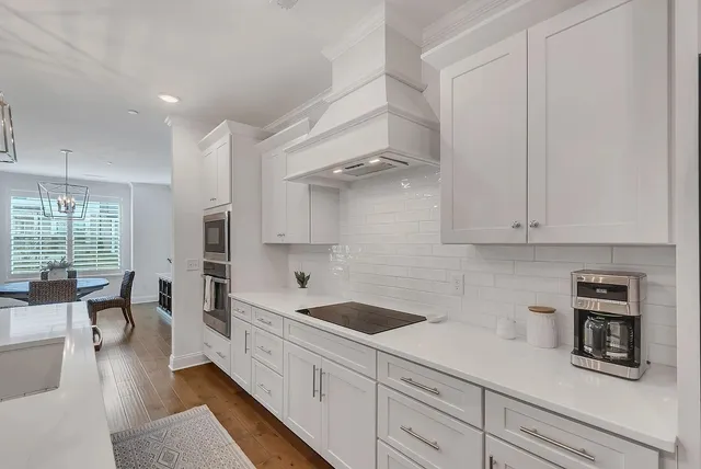a kitchen with white cabinets and sink