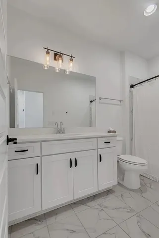 a bathroom with a sink a toilet and mirror