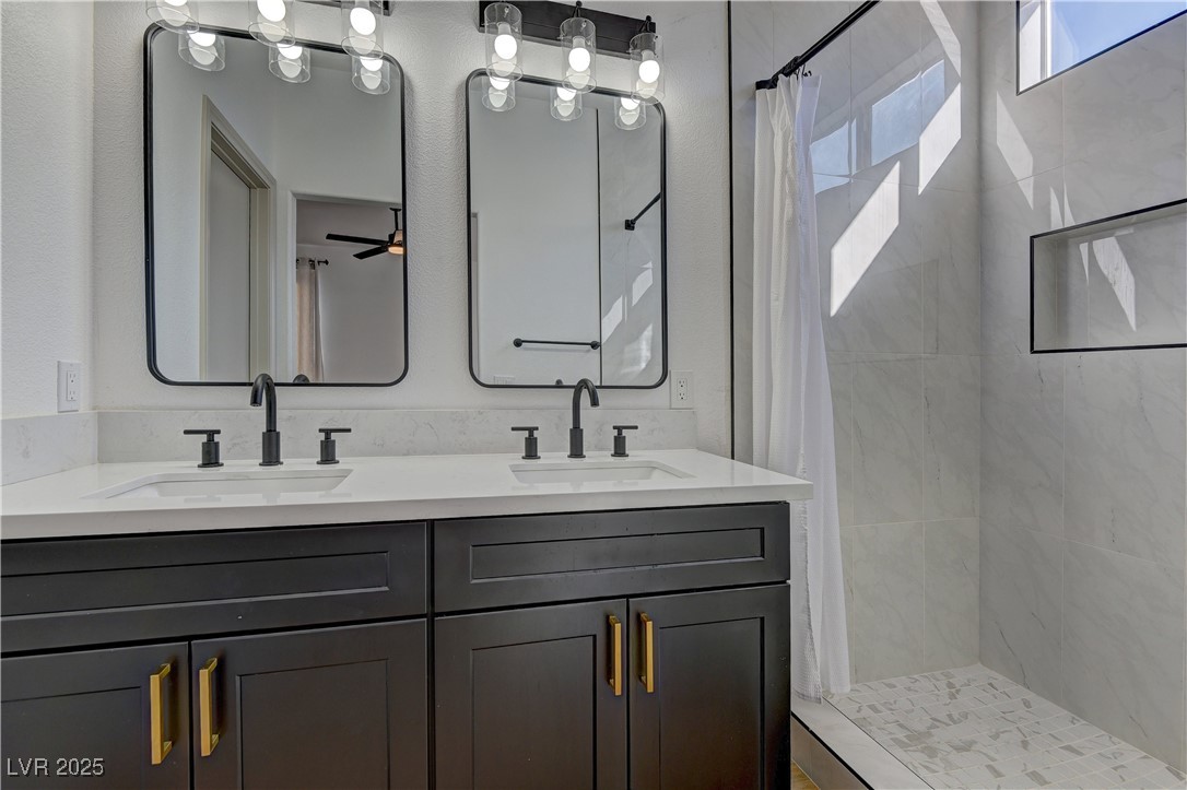1176 Colgate Lane Las Vegas, NV 89110 - Photo 13 of 15 Full bath featuring a shower stall, double vanity, and a ceiling fan