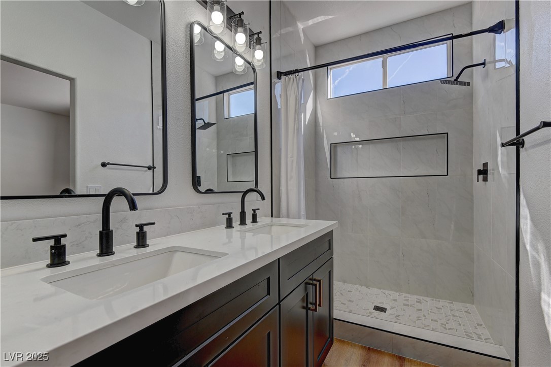 1176 Colgate Lane Las Vegas, NV 89110 - Photo 14 of 15 Bathroom featuring a stall shower, double vanity, and light wood-style floors