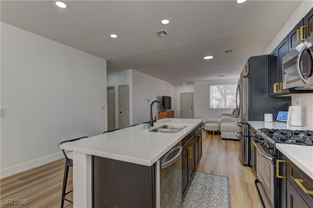 1176 Colgate Lane Las Vegas, NV 89110 - Photo 15 of 15 Kitchen with stainless steel appliances, a kitchen bar, light wood-type flooring, recessed lighting, and open floor plan