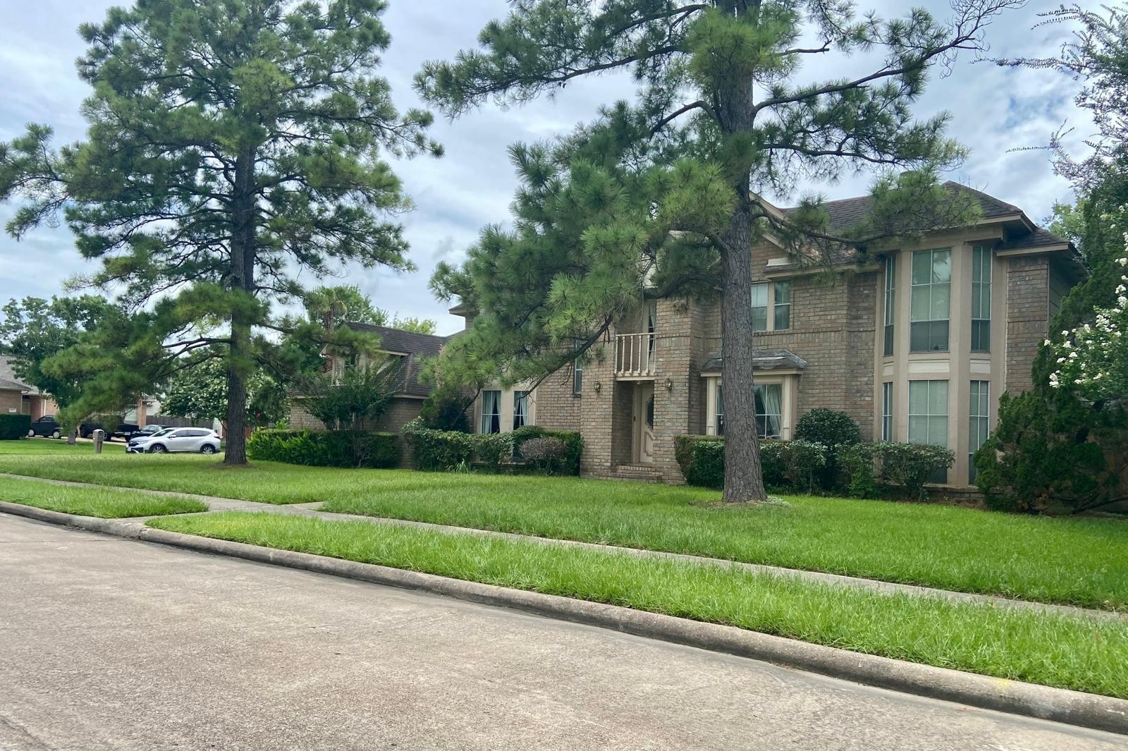 14702 Rancho Vista Drive Houston, TX 77083 - Photo 1 of 11 Two-story brick house with large windows, surrounded by mature trees