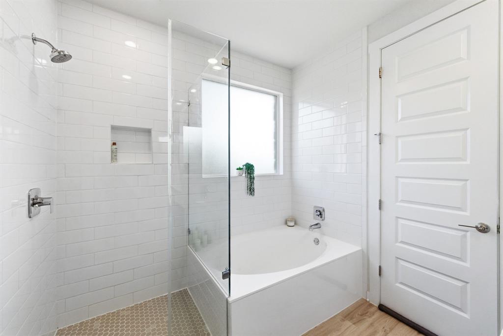 4420 Ingram Road Georgetown, TX 78628 - Photo 17 of 40 Gleaming subway tile surrounds the soaking tub and walk-in shower in this sleek bathroom.