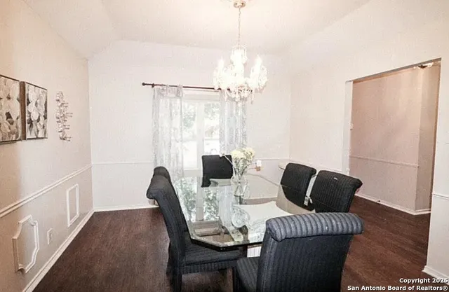 a view of a dining room with furniture a chandelier and wooden floor