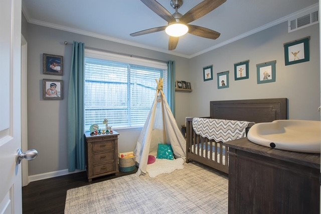 6022 Woodbrook Lane Houston, TX 77008 - Photo 14 of 20 a bedroom with a bed and a chandelier