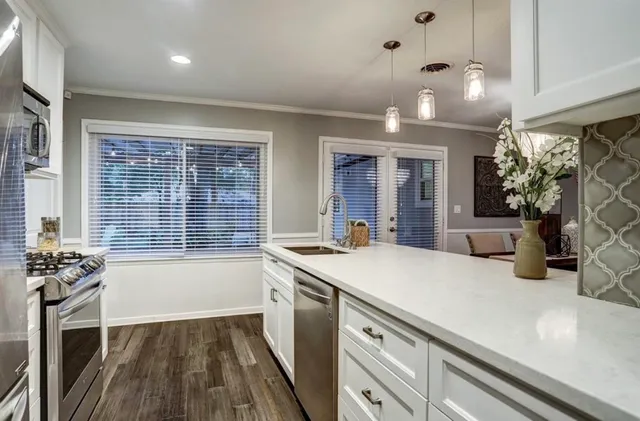 a kitchen with a sink appliances and cabinets