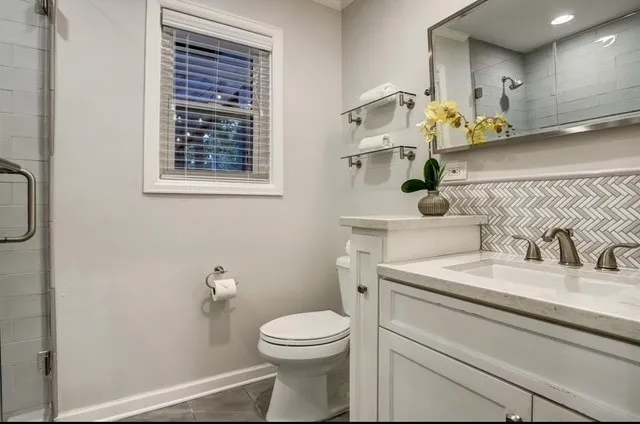 a bathroom with a toilet sink and mirror