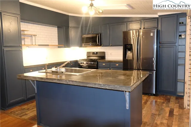 a kitchen with stainless steel appliances granite countertop a sink a refrigerator and a stove