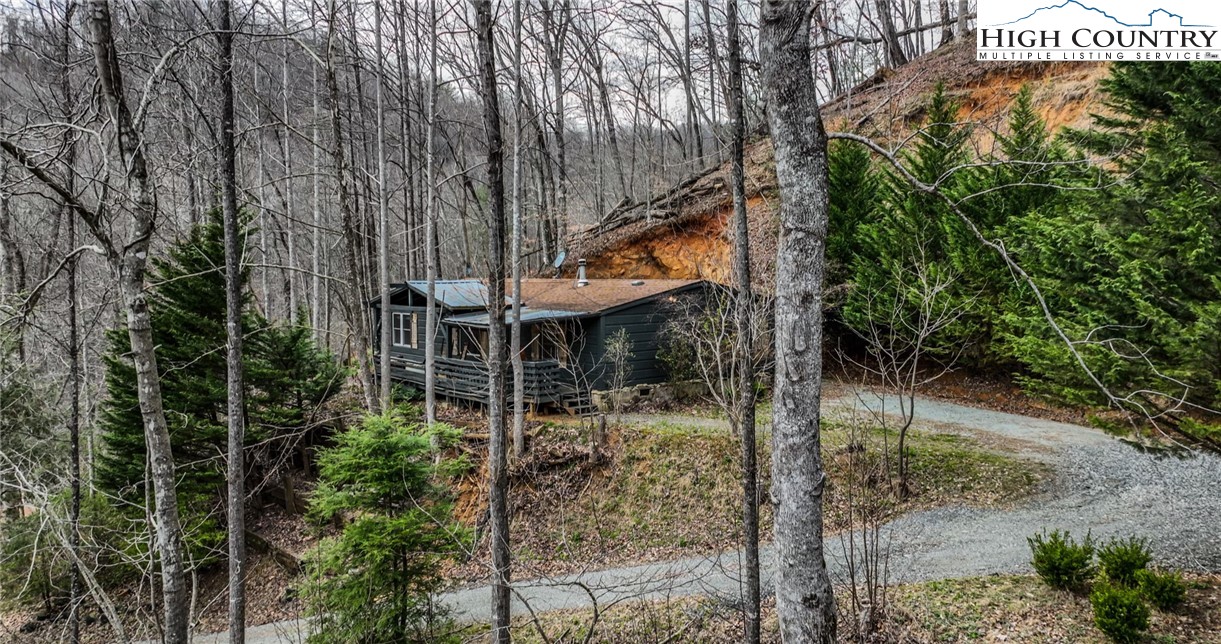 618 Rhymer Branch Road Deep Gap, NC 28618 - Photo 4 of 24 a backyard of a house with table and chairs under an umbrella