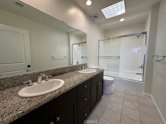 a bathroom with a toilet a sink a mirror and a faucet