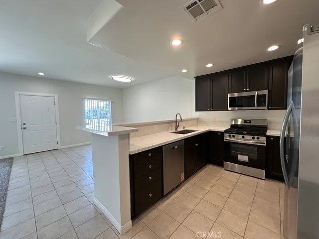 a kitchen with stainless steel appliances wooden cabinets a refrigerator and a sink