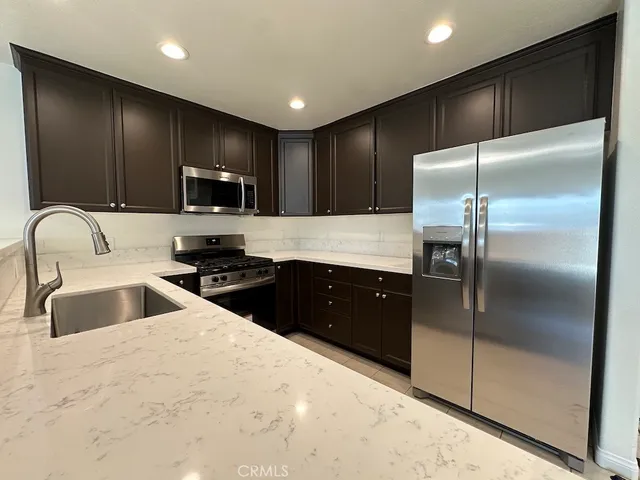 a bathroom with a granite countertop toilet and a sink