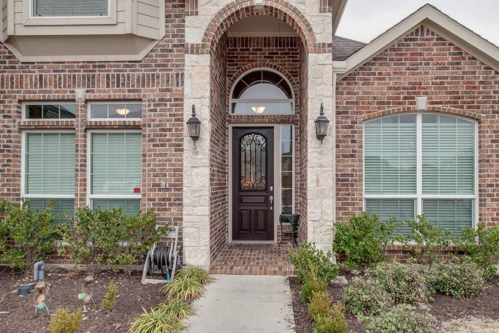 4117 Autumn Path Road Denton, TX 76208 - Photo 3 of 4 Brick facade featuring a prominent arched entryway with stone accents