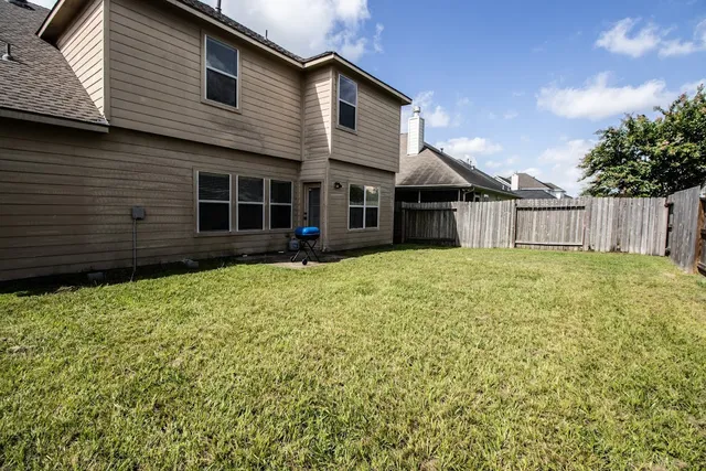a view of a house with a yard and wooden fence