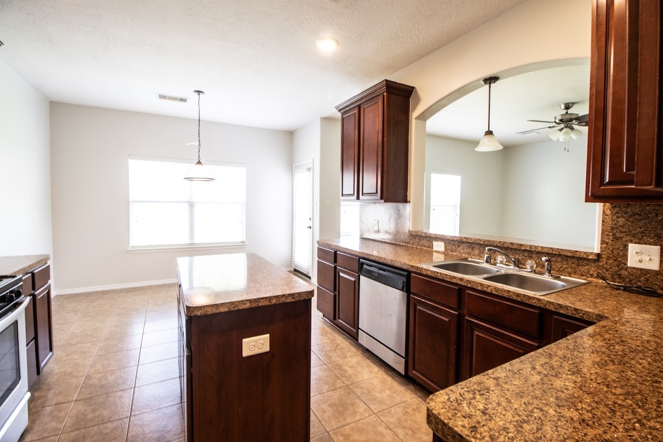 21218 Branchport Drive Houston, TX 77095 - Photo 4 of 18 a kitchen with stainless steel appliances granite countertop a sink a stove and a wooden cabinets