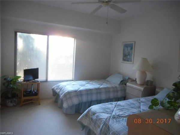 a bedroom with two beds and a chair