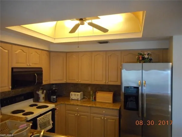a kitchen with a sink a refrigerator and cabinets