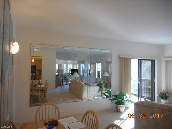 a living room with furniture and potted plants
