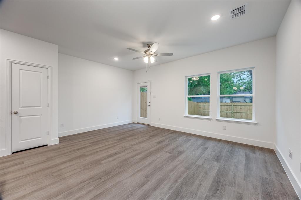 412 East 7th Street, Unit 2 Bonham, TX 75418 - Photo 2 of 12 a view of an empty room with wooden floor and a window