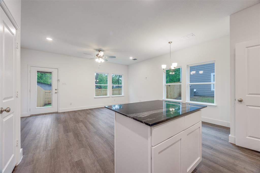 412 East 7th Street, Unit 2 Bonham, TX 75418 - Photo 4 of 12 an open kitchen with kitchen island granite countertop a sink and a granite counter tops