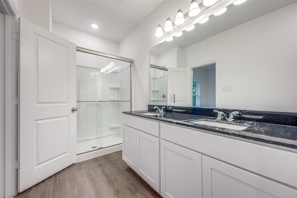 412 East 7th Street, Unit 2 Bonham, TX 75418 - Photo 7 of 12 a bathroom with a double vanity sink and mirror